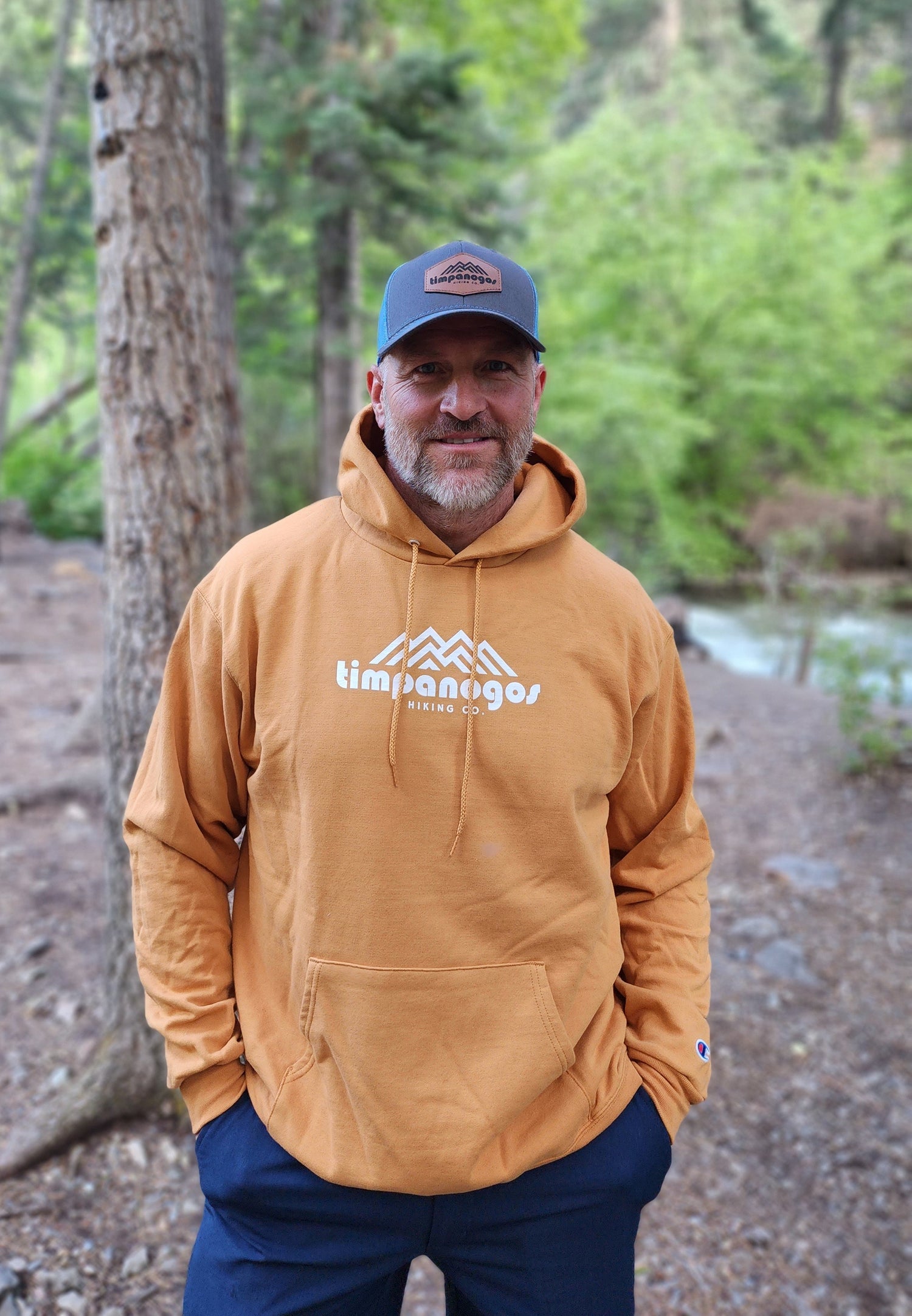 Rugged man in the mountains wearing Timpanogos Hiking Co. hoodie
