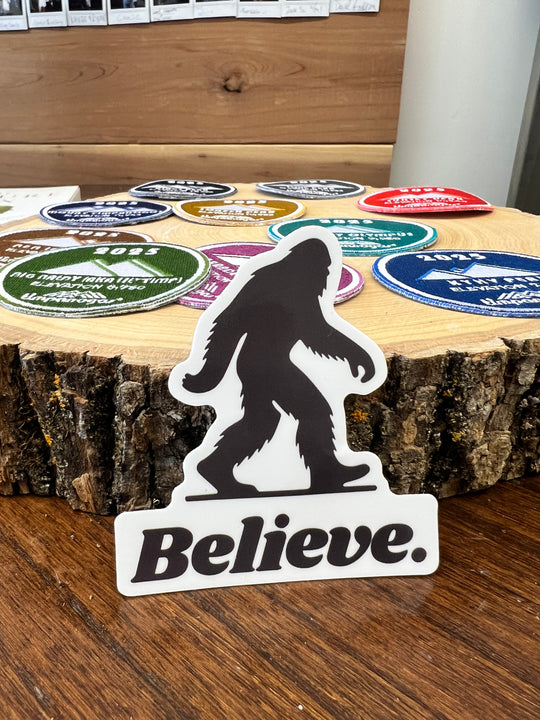 Black and white vinyl sticker featuring a silhouette of Bigfoot walking above bold text that reads "Believe."—a rugged, outdoorsy design perfect for water bottles, coolers, and laptops.