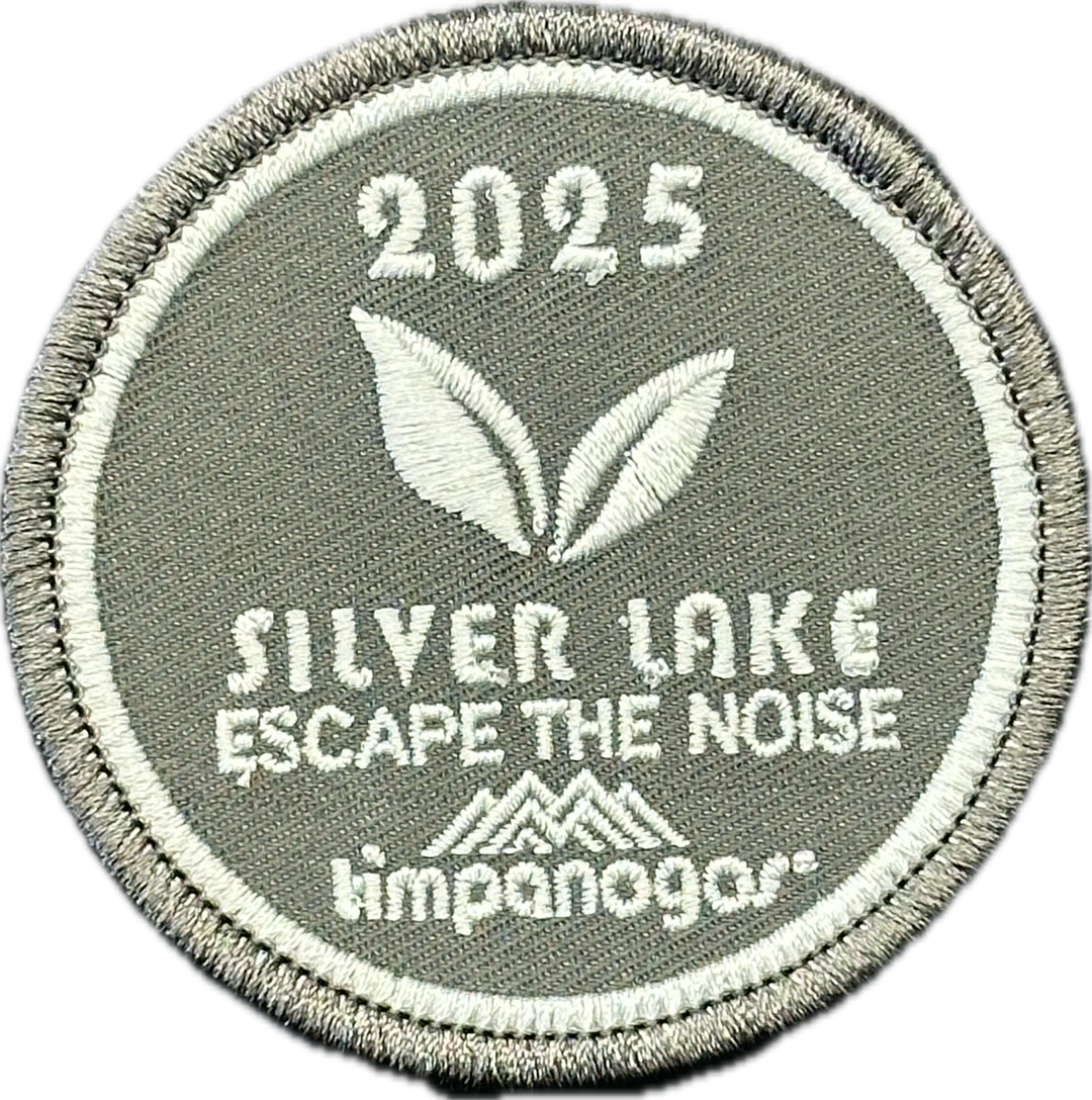 2025 Timpanogos "Silver Lake" patch in light gray with white embroidery. Features two leaf graphics, the phrase "Escape the Noise," and the Timpanogos Hiking Co. logo at the bottom.