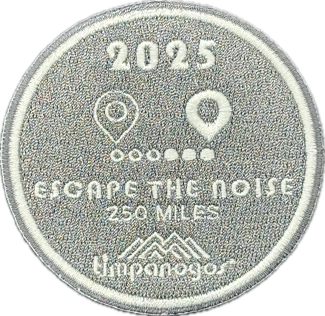 2025 Timpanogos "Escape the Noise" patch in silver with white embroidery, awarded for logging 250 miles. Features a dotted trail between two location pins and the Timpanogos Hiking Co. logo at the bottom.