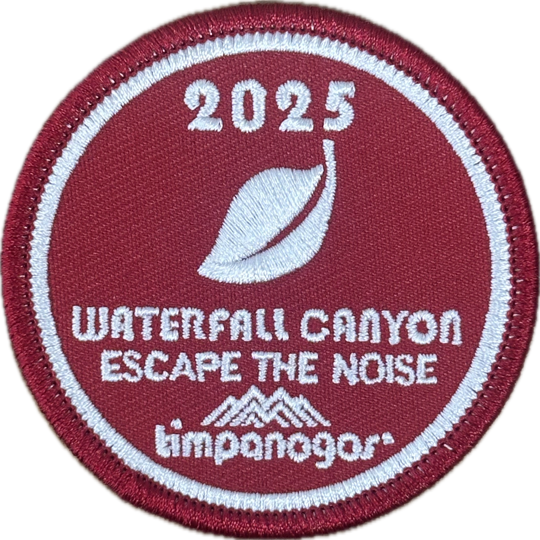 2025 Timpanogos "Waterfall Canyon" patch in deep red with white embroidery. Features a stylized leaf icon above the phrase "Escape the Noise" and includes the Timpanogos Hiking Co. mountain logo at the bottom.