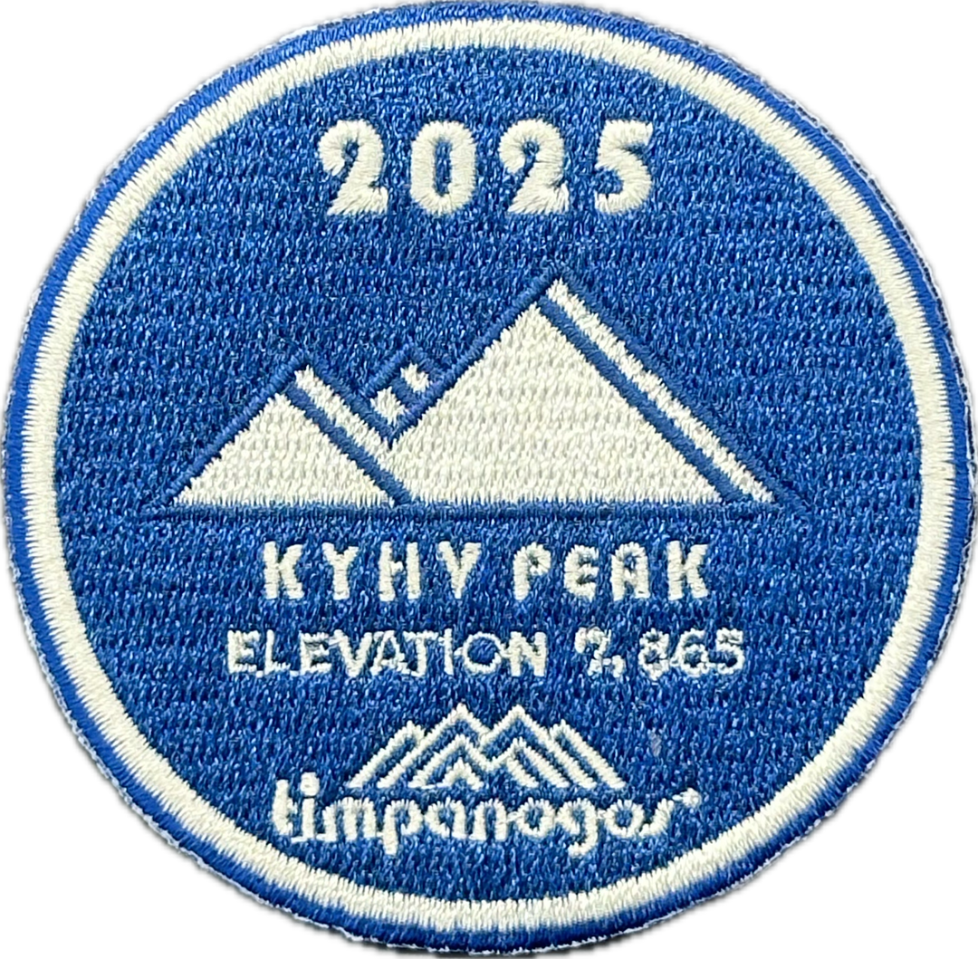 2025 Timpanogos "Kyhy Peak" patch in blue and white, with the mountain design featuring "Kyhy Peak" at an elevation of 2,865 feet. The Timpanogos Hiking Co. logo is displayed below the peak.