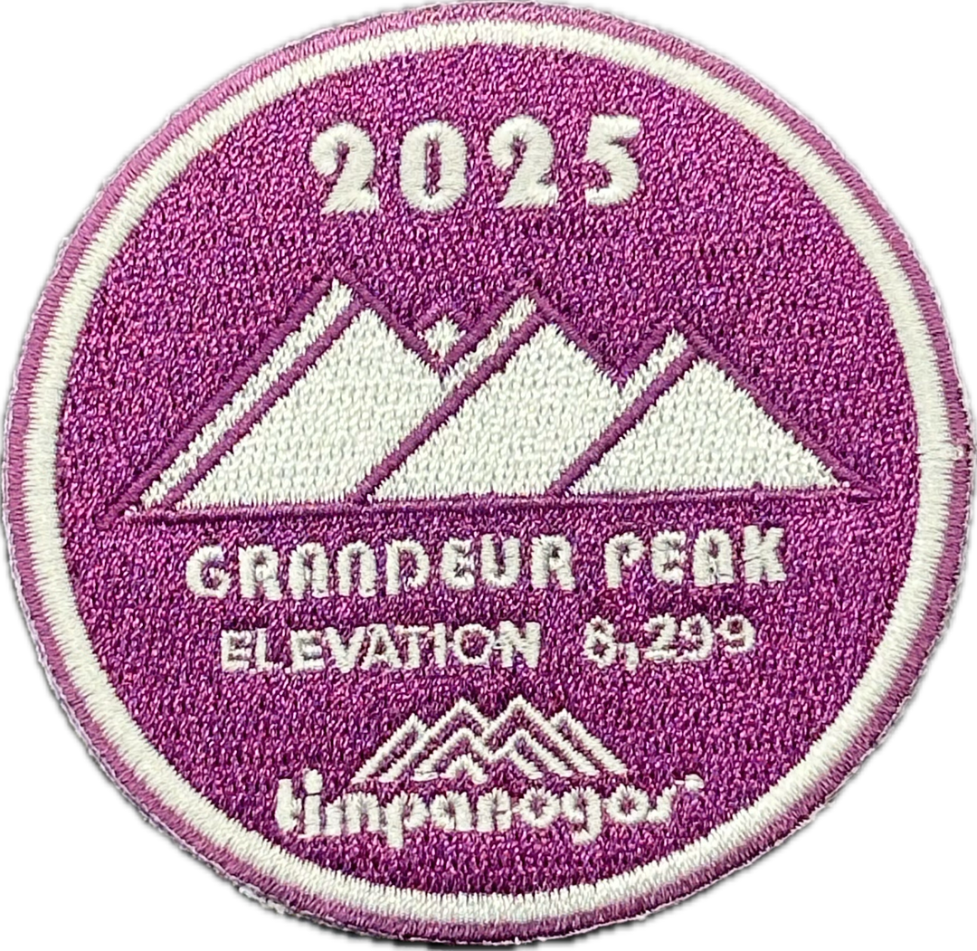 2025 Timpanogos "Grandeur Peak" patch in purple and white, featuring the mountain design with "Grandeur Peak" at an elevation of 8,299 feet, with the Timpanogos Hiking Co. logo at the bottom.