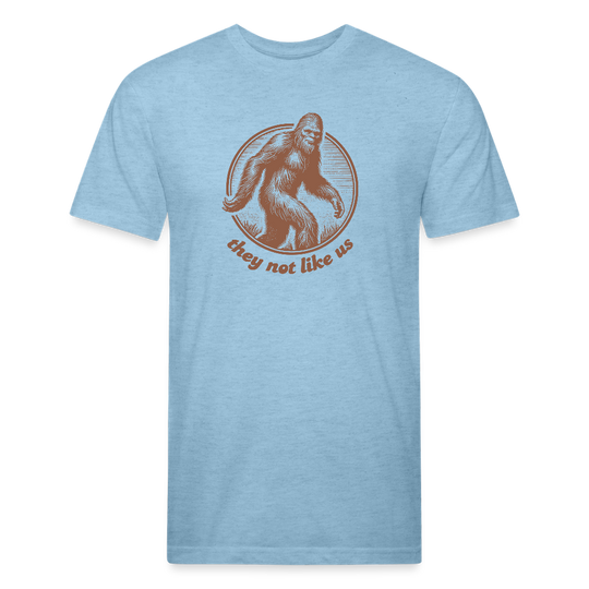 Light blue unisex t-shirt featuring a vintage-style brown illustration of Bigfoot inside a circular frame with the phrase "they not like us" curved below. The design evokes mystery and outdoor adventure with a minimalist, rustic look.