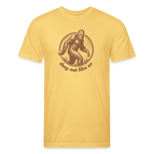 pastel yellow unisex t-shirt featuring a vintage-style brown illustration of Bigfoot inside a circular frame with the phrase "they not like us" curved below. The design evokes mystery and outdoor adventure with a minimalist, rustic look.