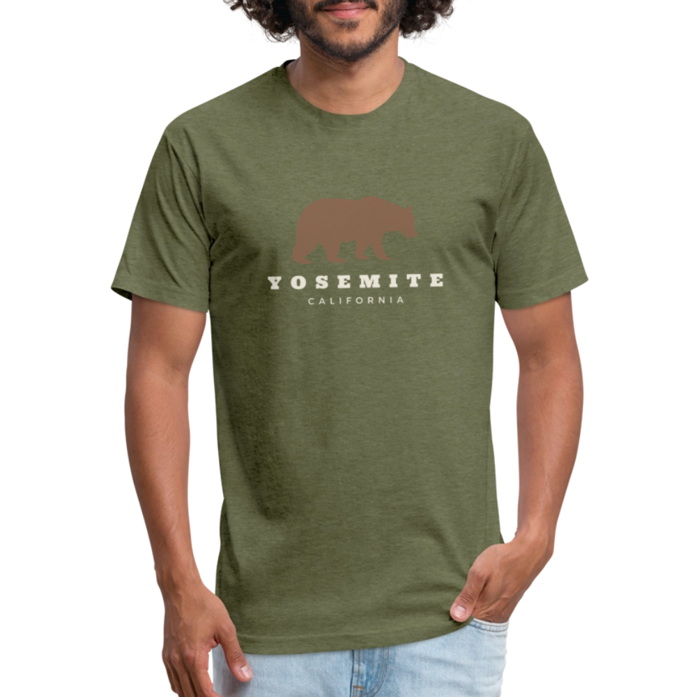 Man wearing a Heather Military Green t-shirt with a Yosemite bear design, accompanied by "Yosemite California" text, standing casually with his hands in his pockets.