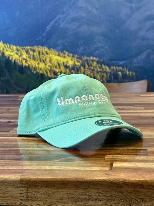 Casual light green hat featuring the Timpanogos Hiking Co. logo embroidered in white, perfect for keeping the sun out of your eyes on your next hiking trip

