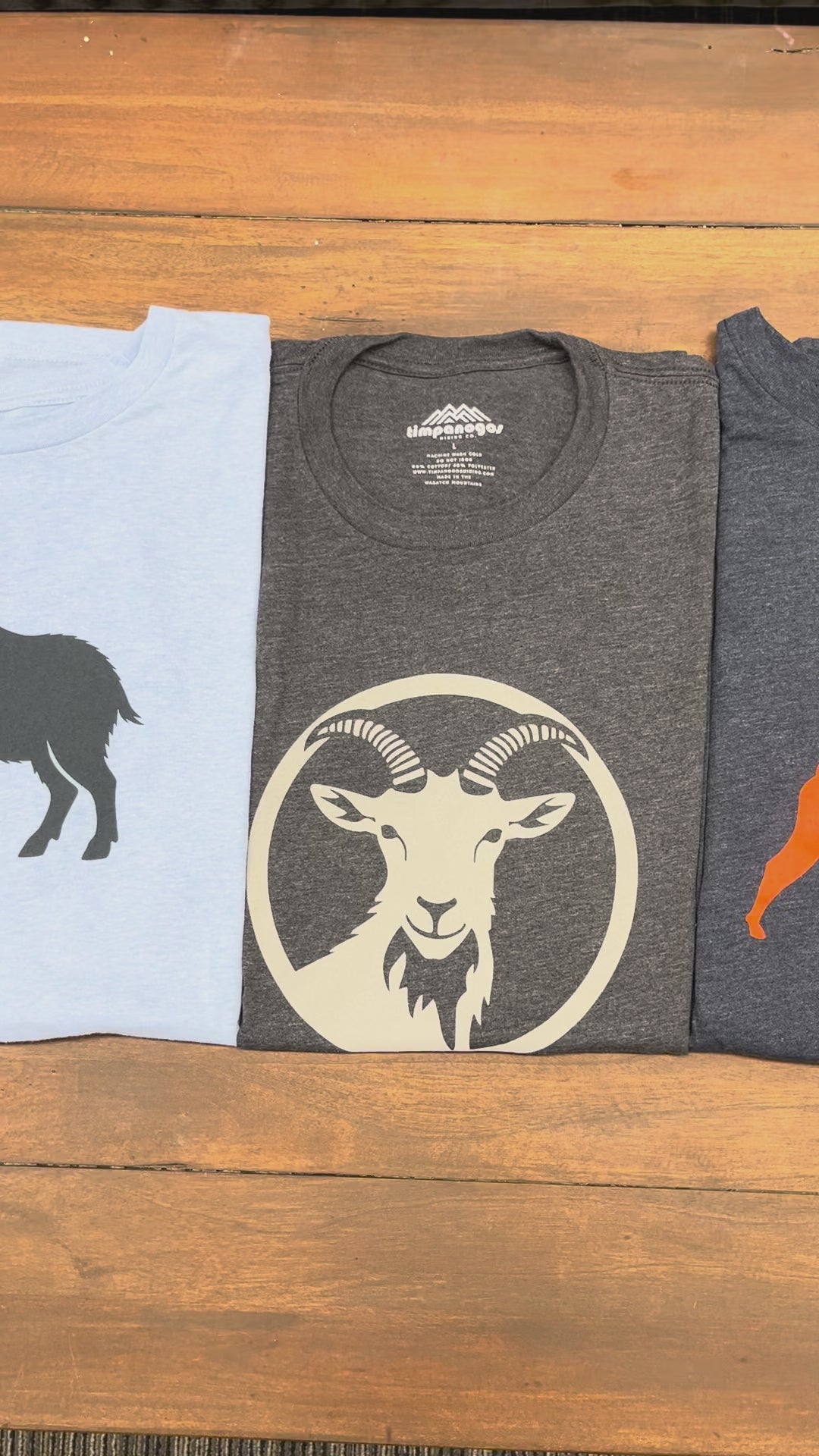 Shirts with goat designs on wooden table.